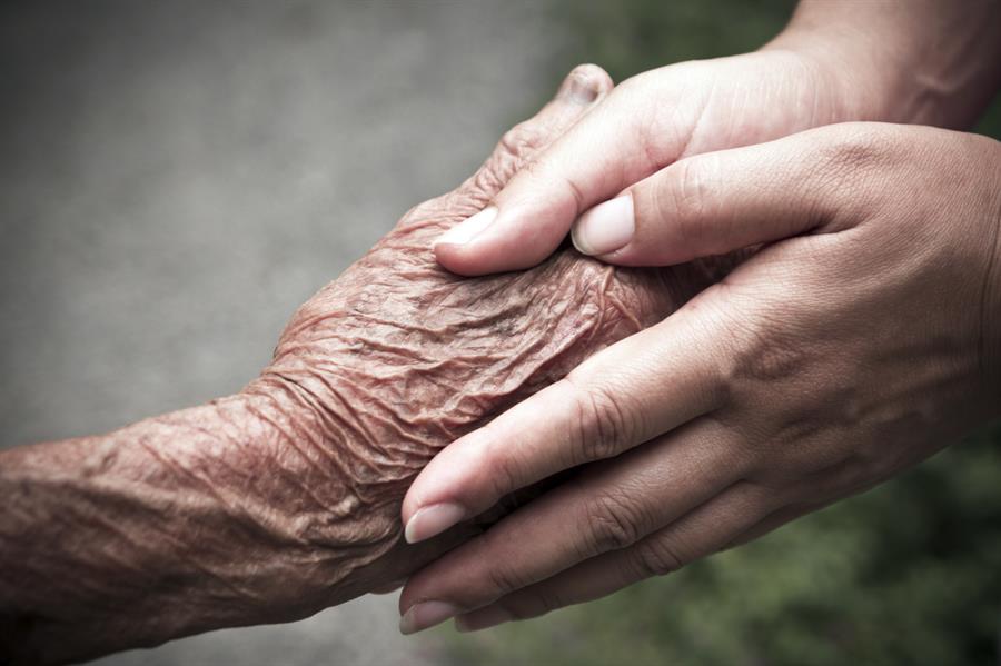 Younger and older caregiver hands